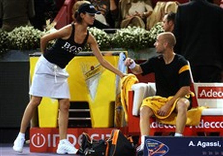 Andre Agassi beder en af model-boldpigerne om drikkevarer under tirsdagens kamp mod hviderusseren Max Mirnyi. Det fik han naturligvis, men amerikaneren mener ikke, at nyskabelsen er godt for sporten.   Foto: Alvaro Hernandez/AP 