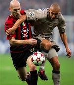 Milans forsvarer Jaap Stam (tv.) gav ikke Barcelonas Henrik Larsson mange muligheder foran det italienske mål, men et enkelt skud på overliggeren nåede svenskeren dog at skræmme hjemmeholdets publikum med.   Foto: Luca Bruno/AP 