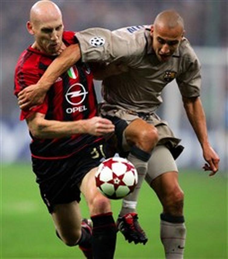 Milans forsvarer Jaap Stam (tv.) gav ikke Barcelonas Henrik Larsson mange muligheder foran det italienske mål, men et enkelt skud på overliggeren nåede svenskeren dog at skræmme hjemmeholdets publikum med.   Foto: Luca Bruno/AP 