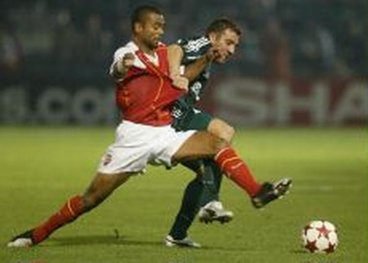 Panathinaikos' Pantelis Konstantinidis i nærkamp med Arsenal's Ashley Cole. - Foto: AP 