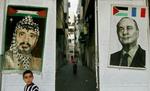 En tæppe i Gaza By med en indvævet fremstilling af Arafat ved siden af en plakat med et fotografi af den franske præsident Chirac. Mange palæstinensere er taknemmelige over den franske hjælp til Arafat. - Foto: AP 