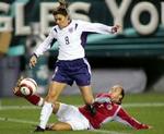 USAs Mia Hamm forsøger at komme forbi danske Bettina Falk. - Foto: AP 