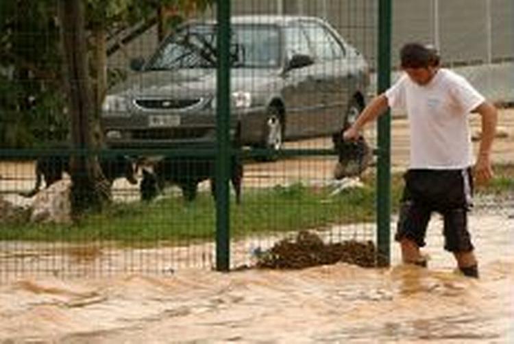 En mand forsøger at komme over en gade i forstaden Aspropyrgos i det vestlige Athen. - Foto: AP 