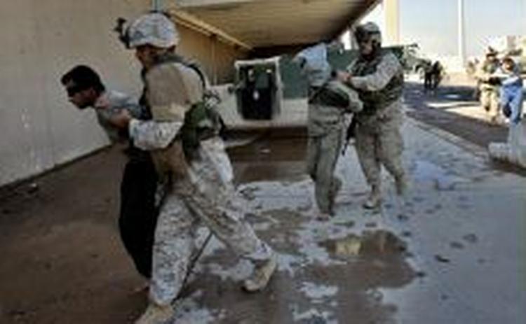 Soldater fra USA s marineinfanteri ifærd med at fjerne tilfangetagne irakere i Fallujah. - Foto: AP 