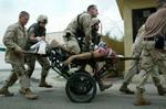 Mens USA buldrer frem i Fallujah har irakiske oprørere gennemført bombeaktioner i Bagdad. Her forsøger amerikanske soldater forgæves at holde liv i en dødeligt kvæstet kollega. - Foto: AP 