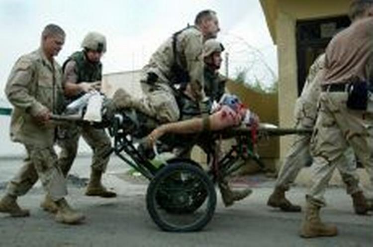 Mens USA buldrer frem i Fallujah har irakiske oprørere gennemført bombeaktioner i Bagdad. Her forsøger amerikanske soldater forgæves at holde liv i en dødeligt kvæstet kollega. - Foto: AP 