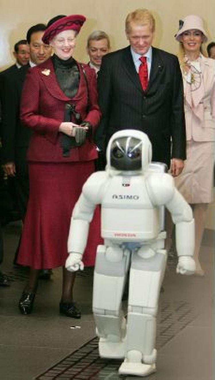 Både dronning Margrethe og ambassadør Poul Hoiness har højden med sig. Det kan ikke helt siges om robotten Asimo. - Foto: AP 