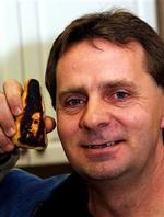 Canadieren Fred Whan viser sig fiskefinger, der ifølge ejeren bærer et portræt af jesus. - Foto: AP 