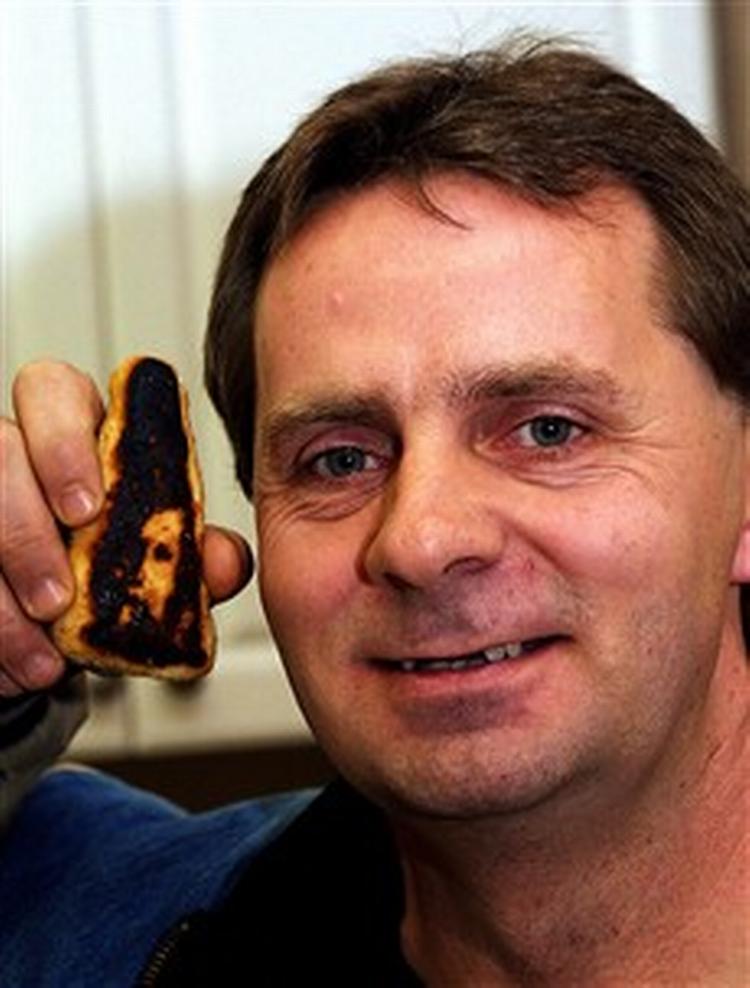 Canadieren Fred Whan viser sig fiskefinger, der ifølge ejeren bærer et portræt af jesus. - Foto: AP 