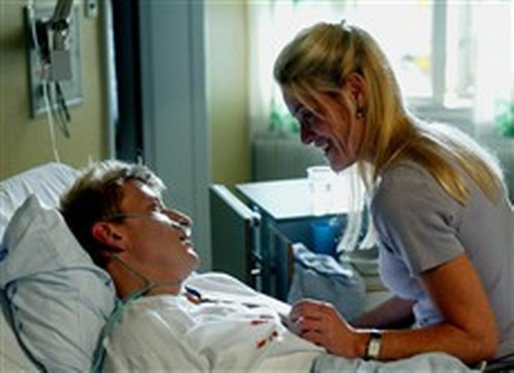 Ørnen alias Hallgrim Hallgrimson alias Jens Albinus   her med Marina Buras på sengekanten   stikkes ned og svæver mellem liv og død på hospitalet. Men det ender jo godt. Eller gør det?   Foto: Bjarne Bergius Hermanse 