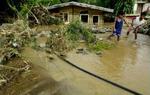 To børn passerer et oversvømmet hus i byen Dingalan, 70 kilometer øst for Manila. - Foto: AP 