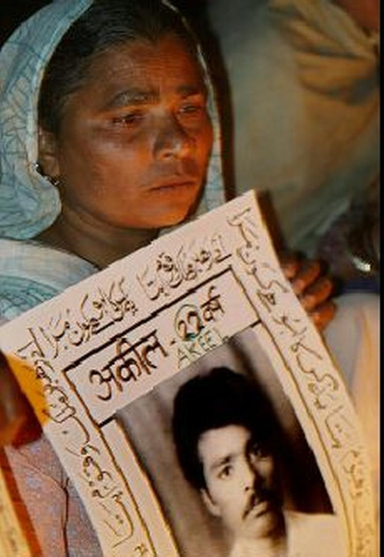 En overlevende efter tragedien i Bhopal holder et fotografi af en slægtning, som døde i giftgaskatastrofen. - Foto: AP 