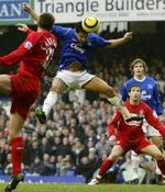 Evertons Tim Cahill (blå) vinder en hovedstødsduel. I kampens sidste sekunder reddede han også et Liverpool-forsøg på målstregen. - Foto: AP 