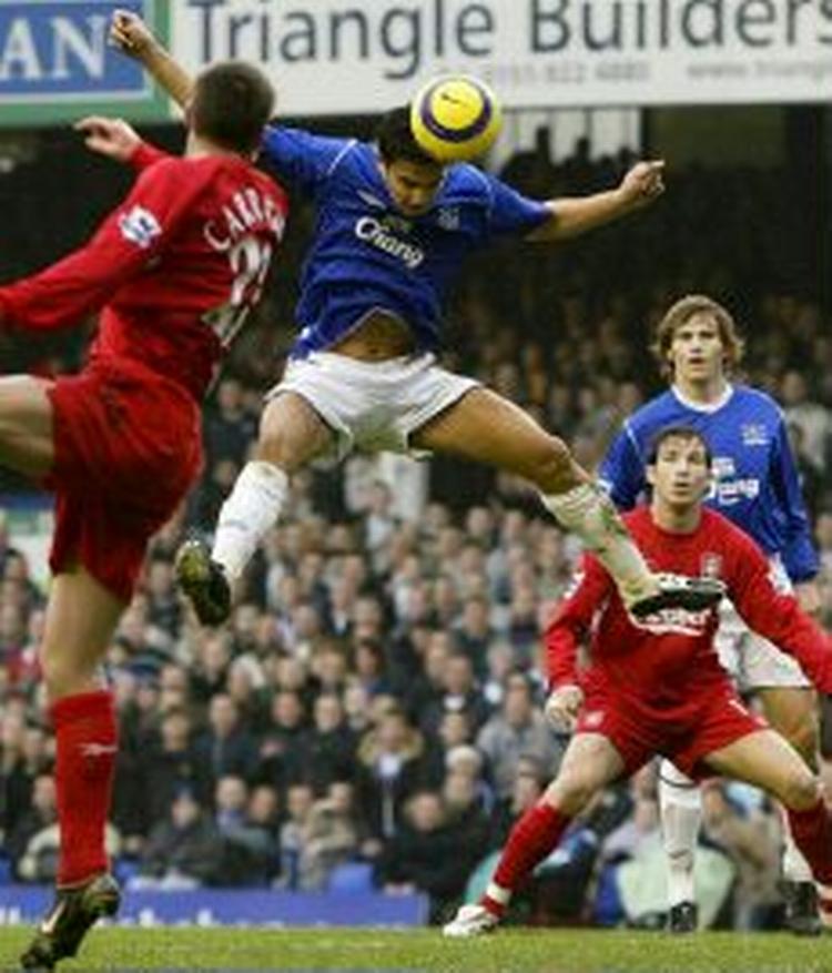 Evertons Tim Cahill (blå) vinder en hovedstødsduel. I kampens sidste sekunder reddede han også et Liverpool-forsøg på målstregen. - Foto: AP 
