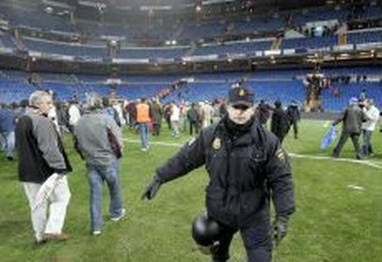En betjent gelejder folk ud af Bernabeus plæne. - Foto: AP 