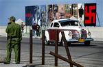 Et hagekors og plakater med torturofre fra Abu Ghraib-fængslet i Irak er cubanernes svar på en amerikansk juleudsmykning, der henleder opmærksomheden på 75 fængslede systemkritikere.   Foto: Cristobal Herrera, AP 