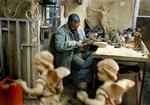 Adel Darawe skærer religiøse figurer ud i træ i et lille værksted i Betlehem. I 34 år har han skåret træfigurer, men nu arbejder han kun to dage om ugen, fordi turisterne holder sig væk. - Foto: AP 