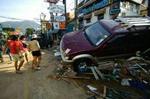 Biler blev kastet rundt som legetøj og huse splintret som glas, da flodbølgen ramte de asiatiske kyster - her øen Phuket i Thailand. - Foto: AP 