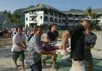 Turister bærer deres sårede ven hen til en helikopter på den Thailandske ø Phi Phi. - Foto: AP 