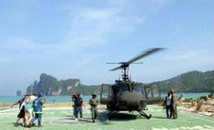 En såret turist bliver båret til en ventende helikopter 