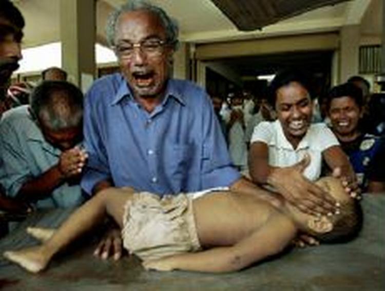 En far står med liget af sin søn i Sri Lanka. Ø-nationen er den hårdest ramte efter flodbølgen, og FN har besluttet at sende katastrofehold til landet. - Foto: AP 