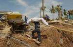En redningsarbejder bærer et lig bort fra stranden på Koh Phi Phi tæt ved Phuket i Thailand. - Foto: AP 