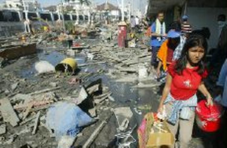 Lokale vandrer i vragresterne i Banda Aceh, Indonesien, som er et af de aller hårdest ramte område. - Foto: AP 