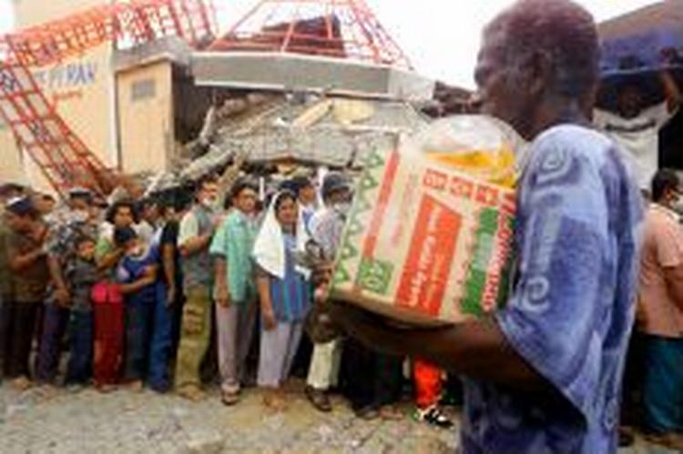 Folk står i kø efter mad i provinshovedstaden Banda Aceh på den nordligste spids af Sumatra. - Foto: AP 