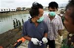 Irwan Irsyad fik reddet sin toårige datter, da flodbølgen ramte Banda Aceh på Sumatra i Indonesien. Nu søger han sammen med sin svoger Sukardan ved Peunayoung-broen efter sin 28-årige kone Afriyant. - Foto: Finn Frandsen 