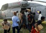 Mænd kæmper desperat om nødhjælpen, der udleveres fra en amerikansk helikopter. - Foto: AP 