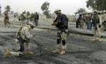 Amerikanskie soldater tilser stedet, hvor en mindre bombe dræbte to i Bagdad-bydelen Amiriya. - Foto: AP 