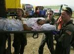 En kvinde bæres ind i en ambulance efter at være blevet transporteret til Banda Aceh i en helikopter. - Foto: AP 