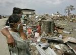 Et indonesisk par betragter ødelæggelserne efter flodbølgen i Banda Aceh. - Foto: AP 