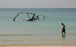 En britisk turist spadserer langs strande i ét af ramte områder i Thailand. - Foto: AP 
