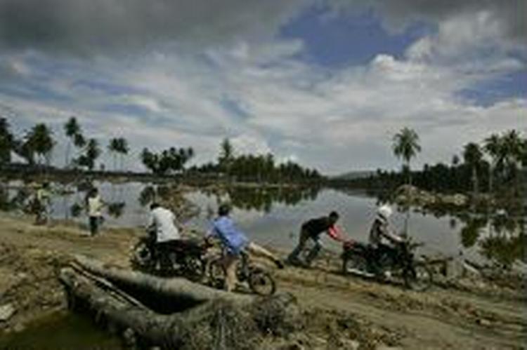 Folk hjælper hinanden over en nødbro i Banda Aceh i Indonesien. - Foto: AP 