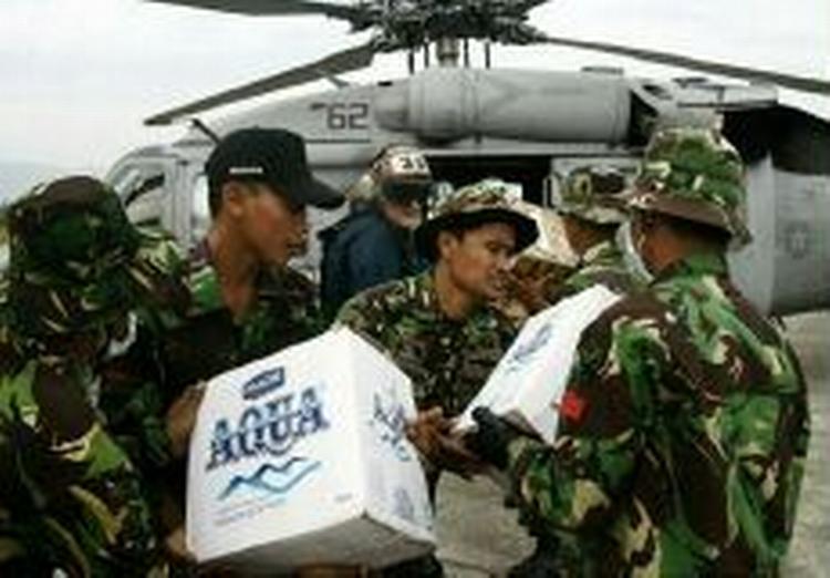 Amerikanske og indonesiske soldater laster nødhjælpsforsyninger på en amerikansk helikopter i Banda Aceh lufthavn. - Foto: APA! 