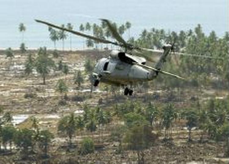 En amerikansk militærhelikopter hjælper med nødhjælpsarbejdet i Aceh-provinsen på Sumatra. Med udgangen af marts er det slut. - Foto: AP 