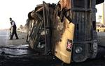 Irakisk politimand opsamler våben fra en udbrændt britisk kampvogn efter et trafikuheld i Bagdad.   Foto: Mohammed Khalil/AP 