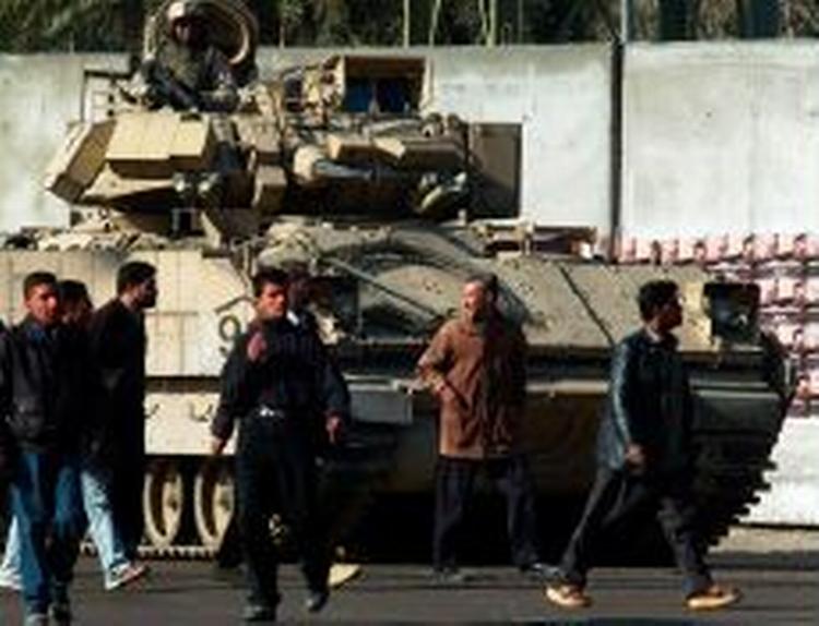 Irakere foran en amerikansk kampvogn. - Foto: AP 