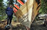 En fisker nord for Phuket bygger en ny traditionel træbåd efter at have tabt både båd og fiskegrej under flodbølgen anden juledag.   Foto: David Longstreath/AP 