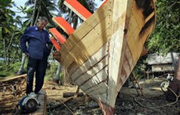 En fisker nord for Phuket bygger en ny traditionel træbåd efter at have tabt både båd og fiskegrej under flodbølgen anden juledag.   Foto: David Longstreath/AP 