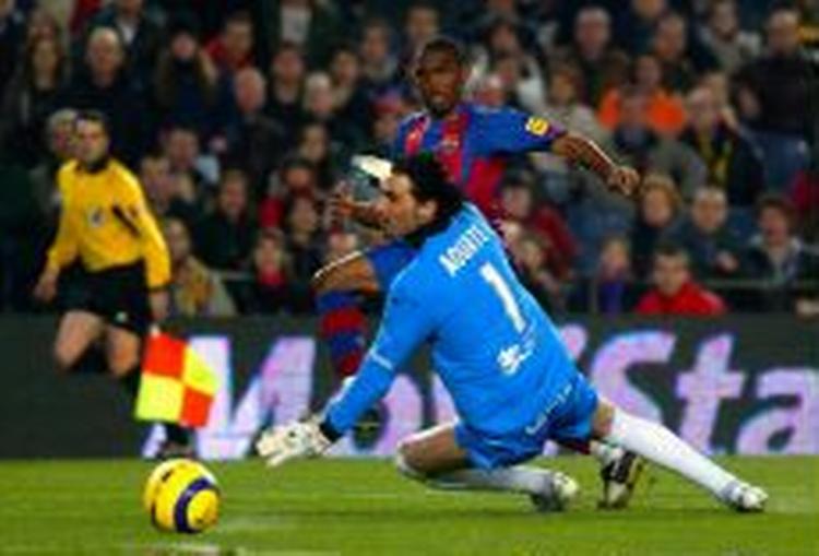 Samuel Eto'o fra Cameroun sparker bolden mellem benene på Santanders keeper og bringer Barcelona på sejrskurs med sit sæsonmål nr. 15. - Foto: AP 