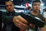 En gæst på en våbenudstilling i Beijing ser nærmere på en østrisk Glock pistol. - Arkivfoto: AP 