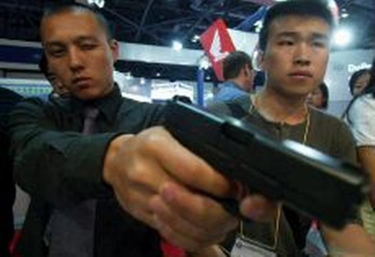 En gæst på en våbenudstilling i Beijing ser nærmere på en østrisk Glock pistol. - Arkivfoto: AP 