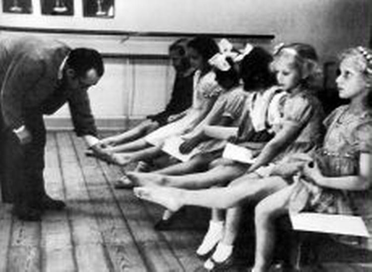 BALLETASPIRANTER. Mester Lander inspicerer fødder ved en optagelsesprøve.   Foto fra bogen: Ukendt fotograf 