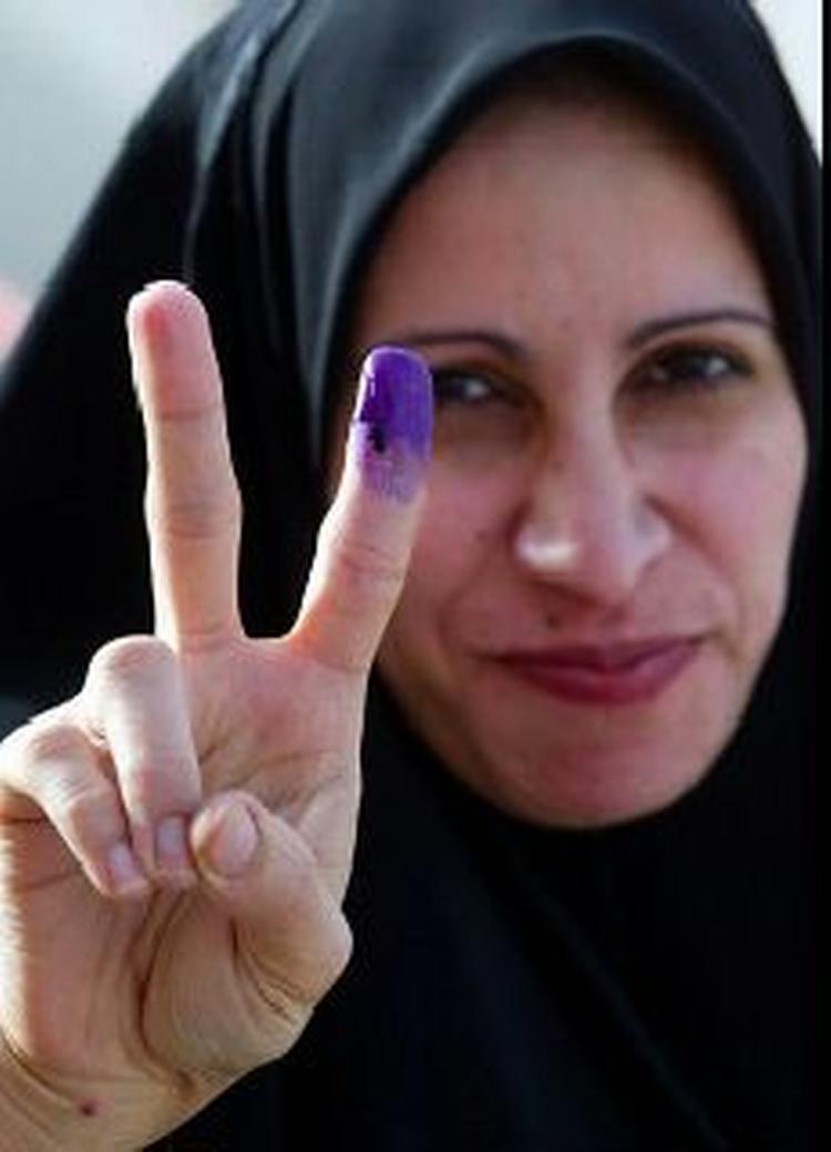 En irakisk kvinde giver et 'V' tegn efter hun har afgivet sin stemme i det sydlige Irak. - Foto: AP 