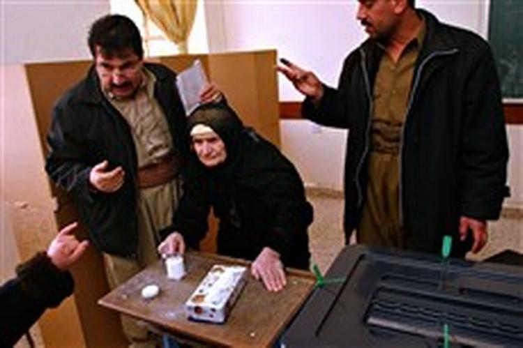 En kvinde afgiver sin stemme i Irak. De danske politikere er tilfredse med valgets afvikling. - Foto: AP 