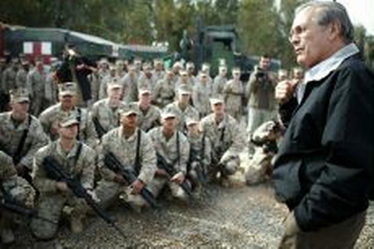 Donald Rumsfeld, der her taler til en gruppe marinesoldater, har to gange sagt op. - Foto: AP 