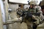 En amerikansk marinesoldat sparker døren ind til et hus i Mosul i jagt på illegale våben. - Foto: AP 