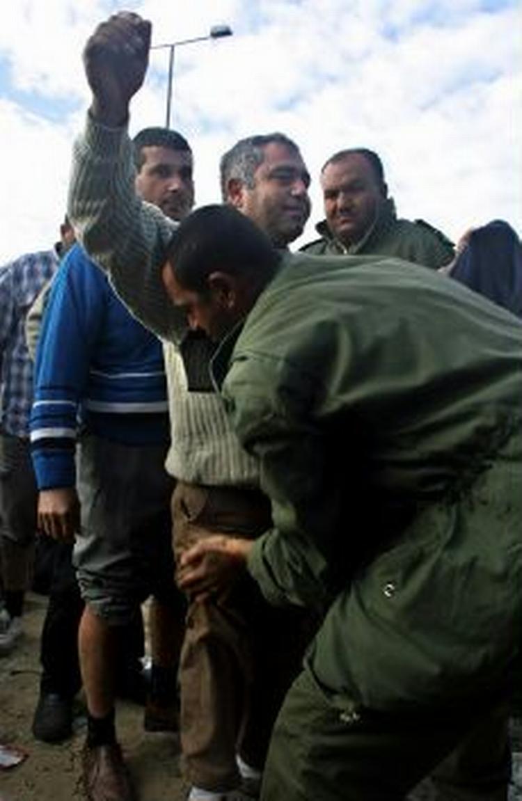 En palæstinensisk sikkerhedsvagt kropsvisterer palæstinenserere på vej ind i Israel. - Foto: AP 